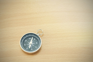 compass on old wood background with space for text.