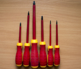 A set of insulated screwdrivers on wooden background