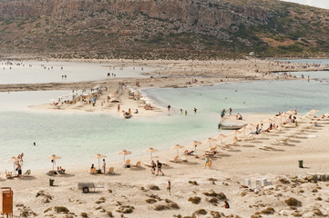 Ludzie spędzający wolny czas na plaży w Grecji - obrazy, fototapety, plakaty