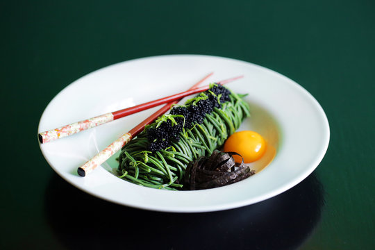 Caviar and green spirulina spaghetti noodles with egg yolk