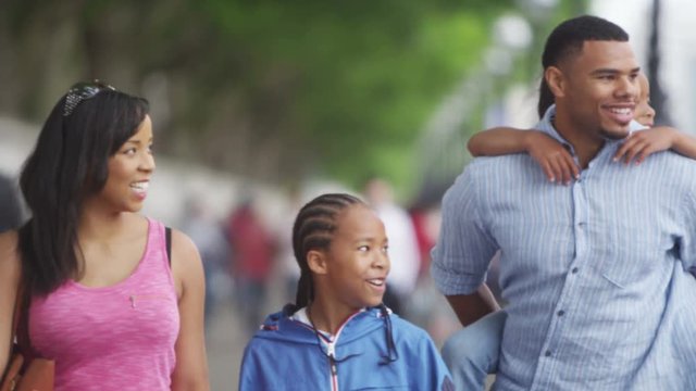  Happy African American Family Sightseeing In London, Walking Along Path Beside The River Thames. 