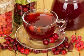 cup of tea from the hips, teapot and fresh berries closeup 