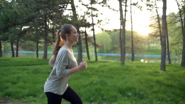 young woman runs in park slow motion