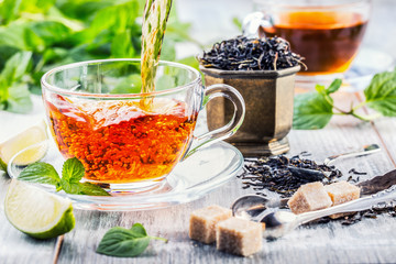 Tea. Mint Tea. Herbal tea. Mint leaf. Mint leaves. Tea in a glass cup, mint leaves, dried tea, sliced lime. herbs tea and mint leaves on a slate plate in a restaurant or teahouse tea room.