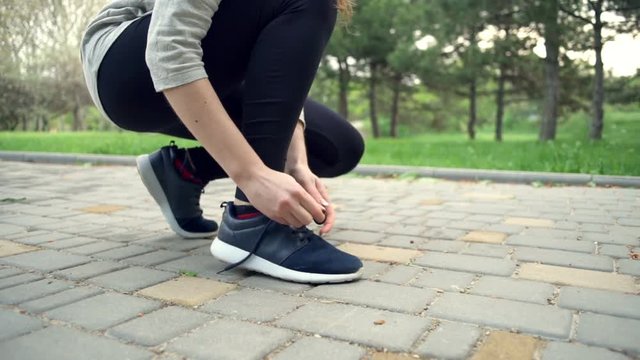 close up woman tying the shoelaces slow motion