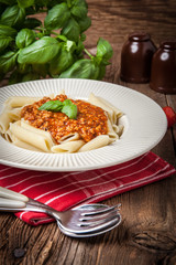 Penne a bolognese on white plate.