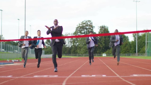  Group of competitive businessmen racing to the finish line at running track