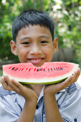 Asian Boy Enjoy Eating The Watermelon.