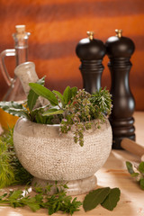 various spices on a wooden table with mortar, pestle and mills.