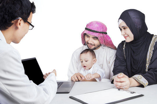Arabic family and doctor look at laptop