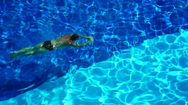 Adult Male Exercising by Swimming. Swimming repeated lengths of a swimming pool to obtain exercise.