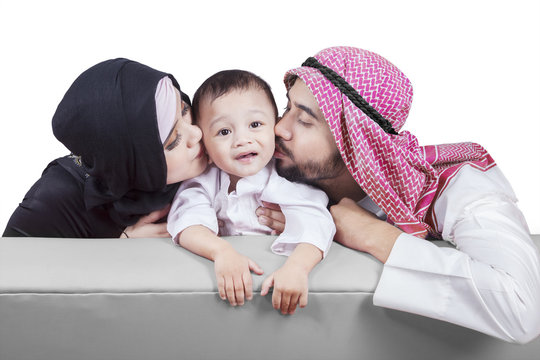 Arabic parents kiss their son