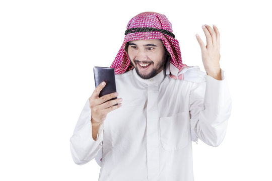 Cheerful Arabic businessman reads message