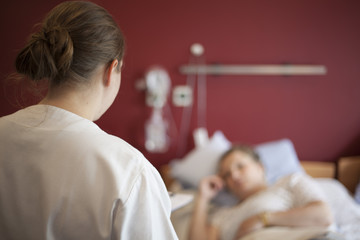 Woman in hospital talking to nurse, copy space