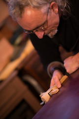 Leather goods craftsman at work in his workshop