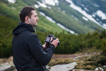 Nature photographer with digital camera on top of the mountain.