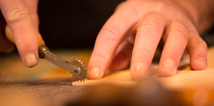 Leather goods craftsman at work in his workshop