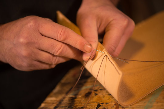 Leather goods craftsman at work in his workshop