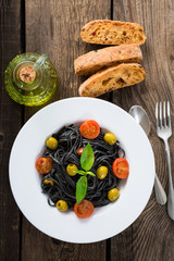 Black pasta with olives and cherry tomatoes