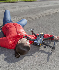 Pretty woman attacked by drone quadrocopter with bleeding head injuries,  lying on sidewalk in the...