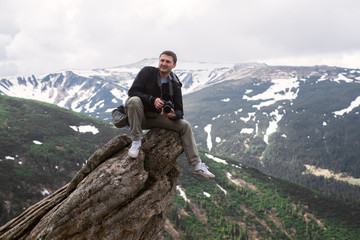 Nature photographer with digital camera on top of the mountain.