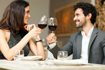 Young coupple toasting wine glasses in a restaurant