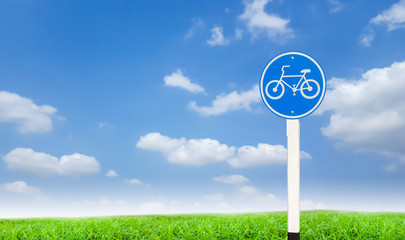 road sign on green grass and blue sky