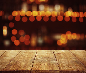 Empty wooden table and bokeh pub, bar of restaurant background.