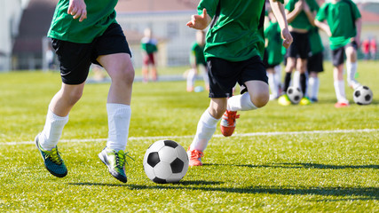 Training and football match between youth soccer teams. Young boys playing soccer game.