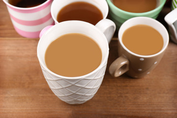 Cups of cappuccino on wooden table, closeup
