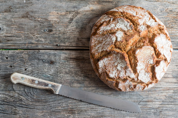 Rusikales Bauernbrot auf Holzplatte mit Messer