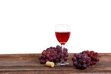 Wine and grape on wooden table against light background