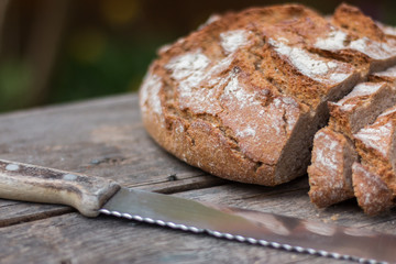 Rusikales Bauernbrot auf Holzplatte mit Messer