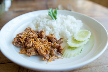 Pork fried with garlic and rice in white disk