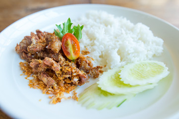 Pork fried with garlic and rice in white disk