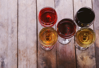 Glasses with wines of different colors on a wooden table