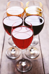 Glasses with wines of different colors on a wooden table