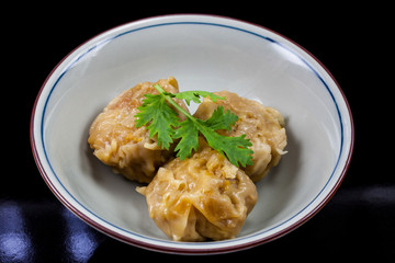 Chinese yum cha, pork dumpling Shumai in white bowl.
