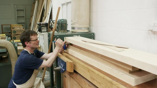  Professional carpenter in his workshop, measuring timber ready to be cut. Shot on RED Epic.
