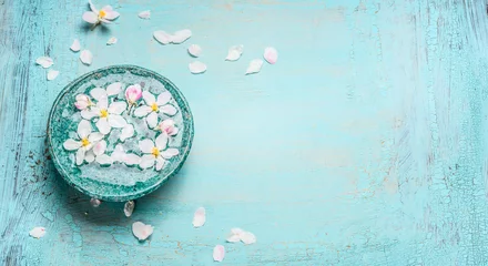 Foto op Canvas Prachtige lentebloesem met witte bloemen in waterkom op Turquoise blauwe shabby chique houten achtergrond, bovenaanzicht. Wellness- en spa-concept. Lentebloesem achtergrond, banner © VICUSCHKA