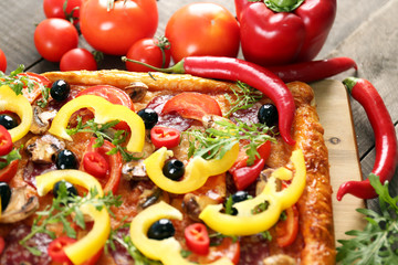 Rectangle delicious pizza and vegetables on the table, close-up