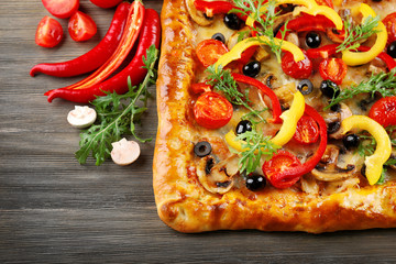 Freshly homemade pizza on wooden background