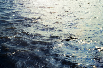 Water surface with ripples and sunlight reflections
