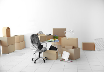 Moving cardboard boxes and personal belongings in empty office space