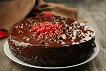 Chocolate cake with cranberries on wooden table, closeup