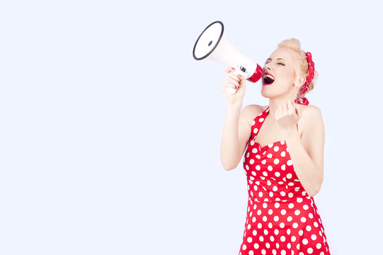 Young woman holding megaphone, dressed in pin-up style red dress