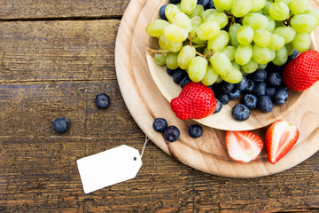 seasonal fresh fruits in a bowl on wooden table, sign with copys
