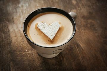 Cup of coffee with marshmallow on wooden table