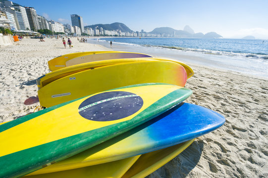 Brazilian flag stand up paddle surfboards stacked on the beach at Copacabana, Rio de Janeiro Brazil