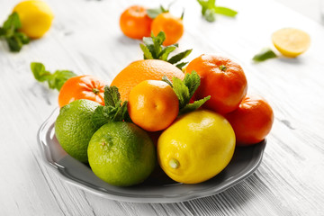 Set of different citrus fruit on light wooden table
